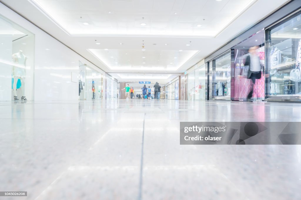 Motion blurred customers walking in shopping mall, Hong Kong