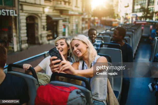 tourists enjoying open top bus tour in the city - open top bus stock pictures, royalty-free photos & images