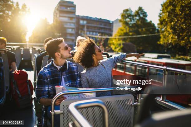 tourists enjoying open top bus tour in the city - open top bus stock pictures, royalty-free photos & images