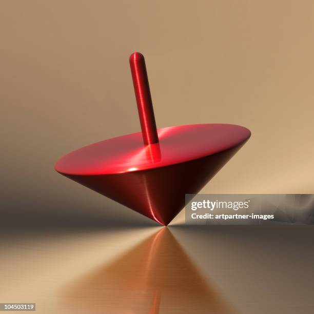 rotating red spinning top on a flat surface - tournoyer photos et images de collection