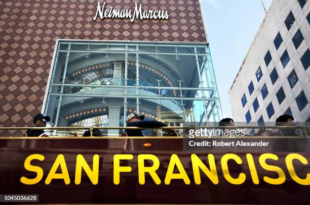 Tourists ride a sightseeing bus past a Neiman Marcus store in San Francisco, California.
