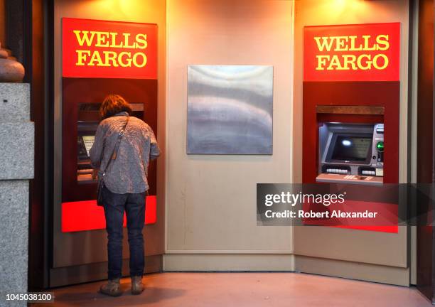 Banking customer uses an ATM machine at a Wells Fargo Bank in San Francisco, California.