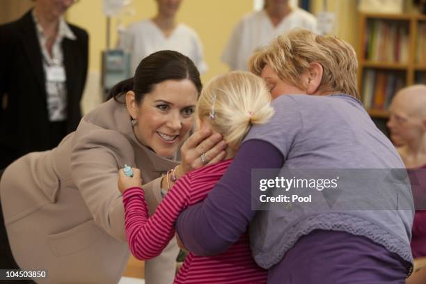 Crown Princess Mary of Denmark talks to childs during her visit at the cancer uni-clinic for kids and teenager on September 28, 2010 in Rostock,...
