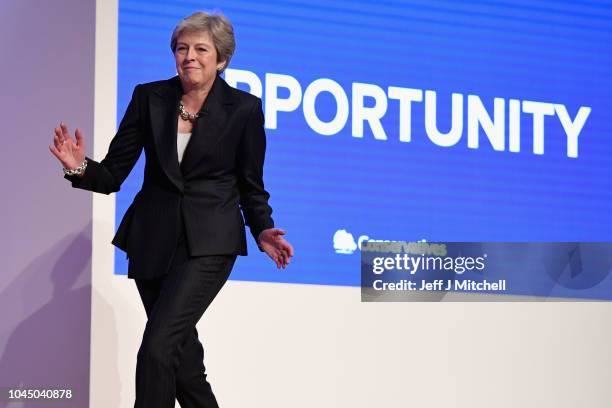 British Prime Minister Theresa May dances as she walks out onto the stage to deliver her leader's speech during the final day of the Conservative...