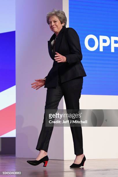 British Prime Minister Theresa May dances as she walks out onto the stage to deliver her leader's speech during the final day of the Conservative...