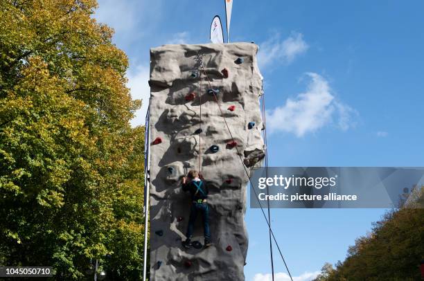 October 2018, Berlin: A boy climbs up an artificial rock on the Straße des 17. Juni at the Bürgerfest, the central celebration of German Unity Day....