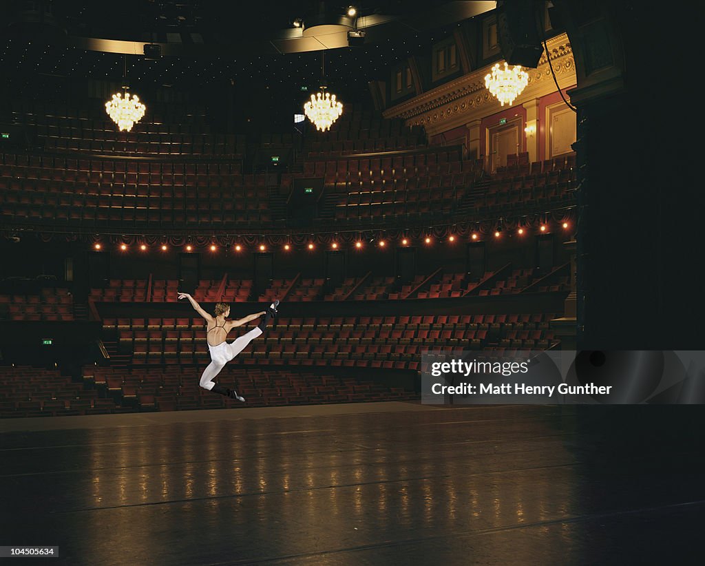 Female ballet dancer jumping onstage