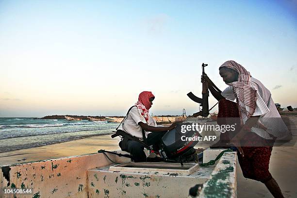 Photo taken on January 4, 2010 shows armed Somali pirates carrying out preparations to a skiff in Hobyo, northeastern Somalia, ahead of new attacks...