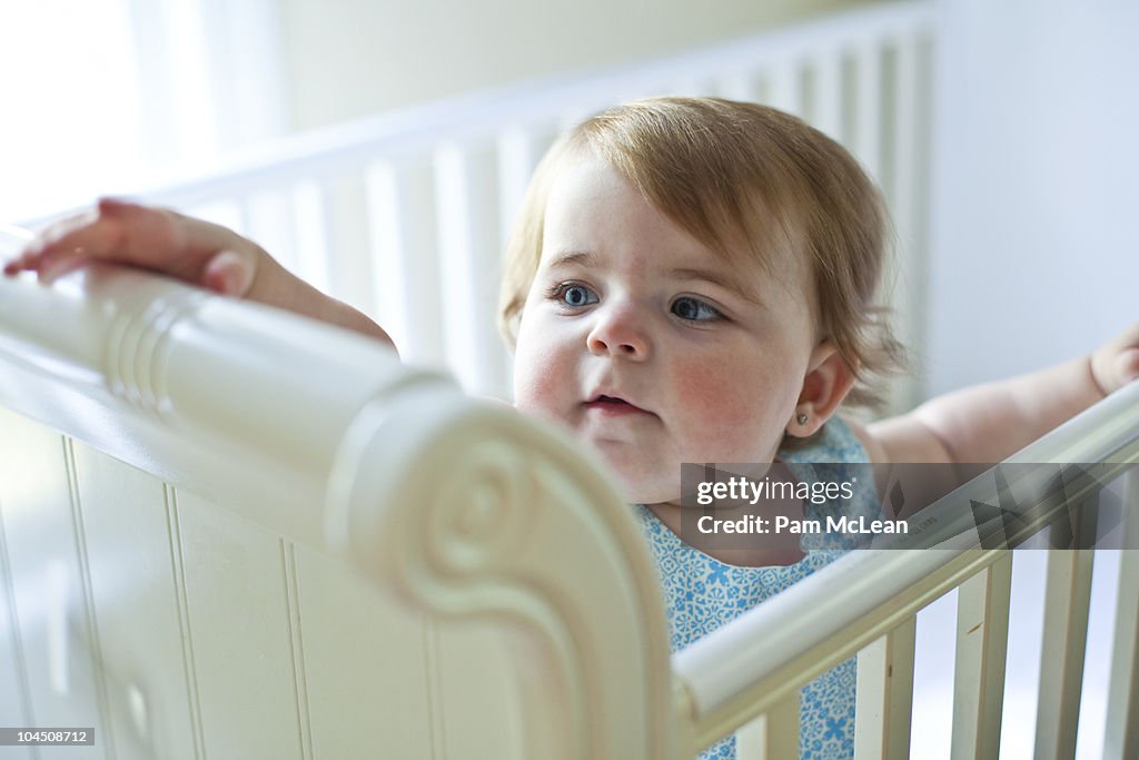 Baby standing in a crib