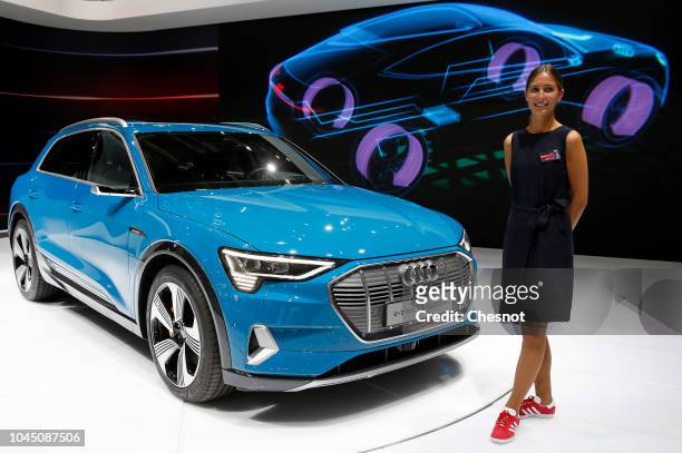 Model poses next to an Audi e-tron 5S Quatto electric automobile is on display during the second press day of the Paris Motor Show at the Parc des...