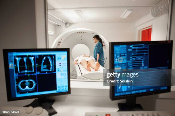 nurse with patient laying in ct-scanner - ct scanner stockfoto's en -beelden