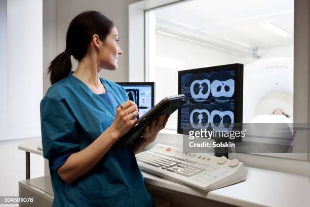 doctor looking at patient in ct-scaner - röntgen stock-fotos und bilder