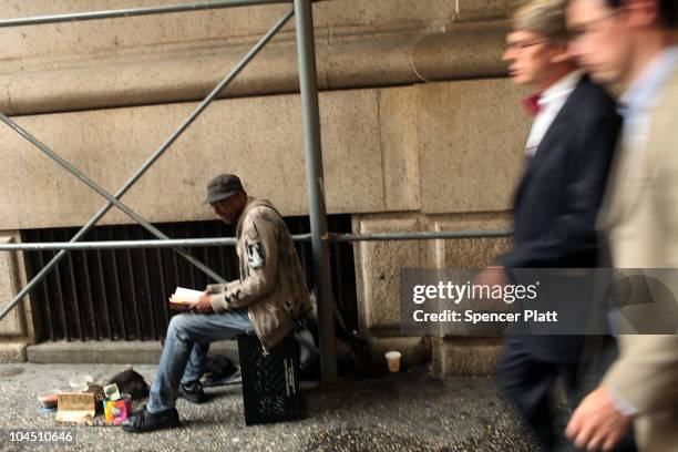 Businessmen walk by a homeless man on the street on September 28, 2010 in New York City. A new report released by the U.S. Census Data shows that the...