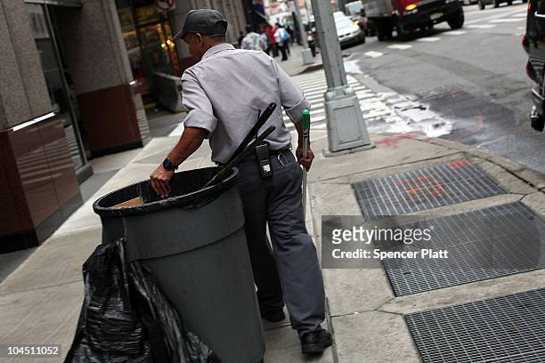 Man cleans garbage from the street on September 28, 2010 in the Brooklyn borough of New York City. A new report released by the U.S. Census Data...