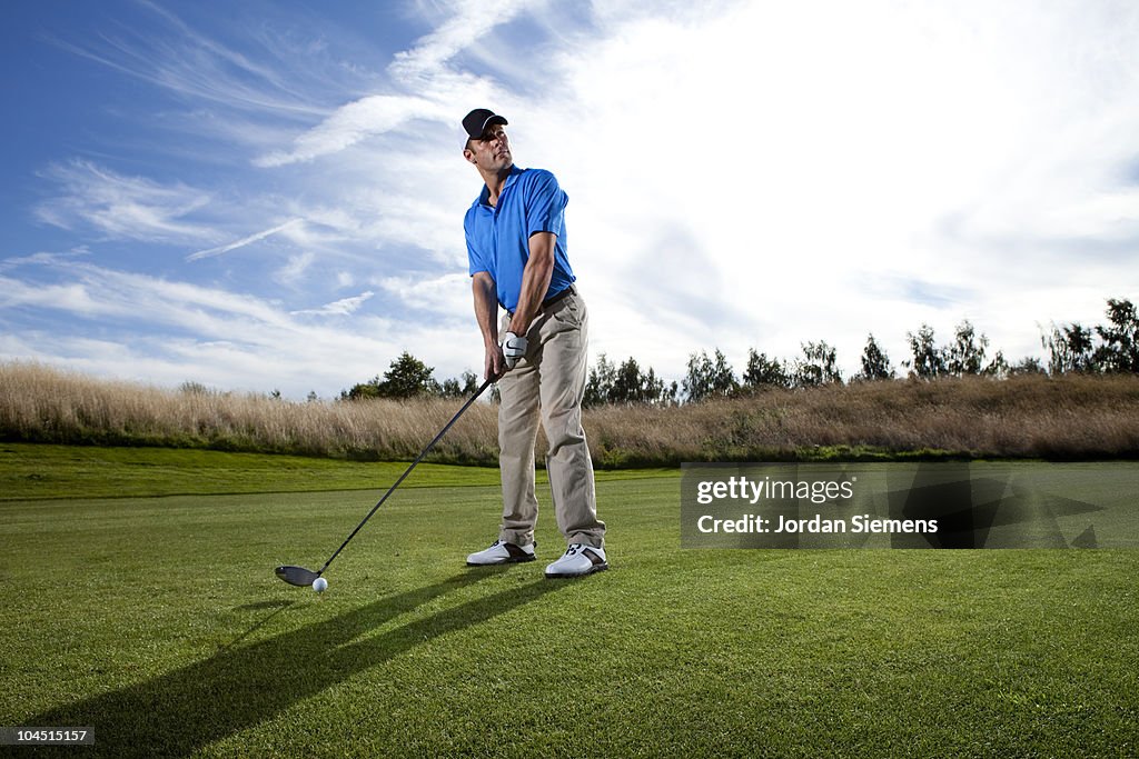 Man preparing to drive his golf ball.