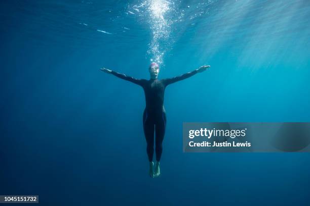 Young Woman Swimmer Plunges into the Deep Unknown, Leaving a Trail of Bubbles that Will Lead her Back to the Surface