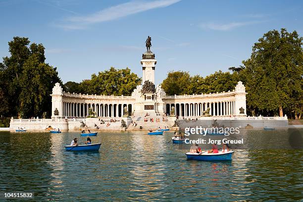 boats on retiro pond, monument to alfonso xi - madrid fotografías e imágenes de stock