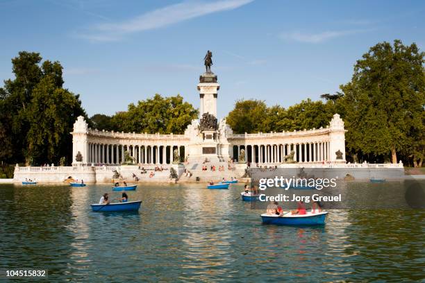 boats on retiro pond, monument to alfonso xi - madrid stock pictures, royalty-free photos & images