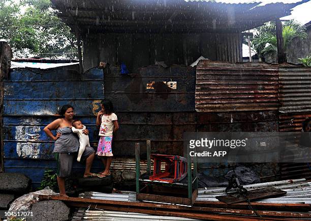Woman and her two daughters wait to be evacuated from Acahualinca neighborhood, in the banks of Xolotlan lake in Managua, on September 28 during...