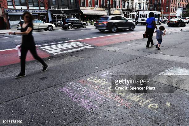 Pedestrians walk by a recent work by Sophie Sandberg who uses colored chalk to draw a quote on the sidewalk from a catcall made towards a woman on...