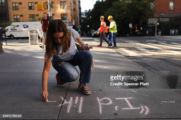 Sophie Sandberg uses colored chalk to draw a quote on the sidewalk from a catcall made towards a woman on October 3, 2018 in New York City. Victims...
