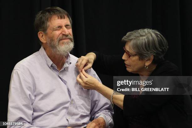 University of Missouri professor George P. Smith has a pin put on his shirt by wife Marjorie before a press conference announcing he has won the 2018...