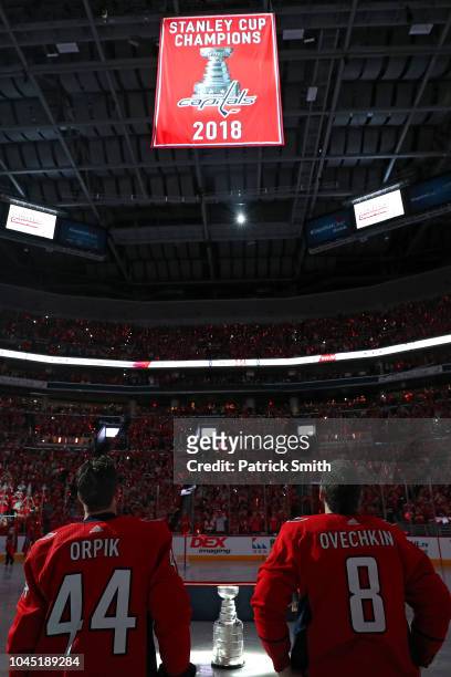 Alex Ovechkin and Brooks Orpik of the Washington Capitals and teammates watch their 2018 Stanley Cup Championship banner rise to the rafters before...