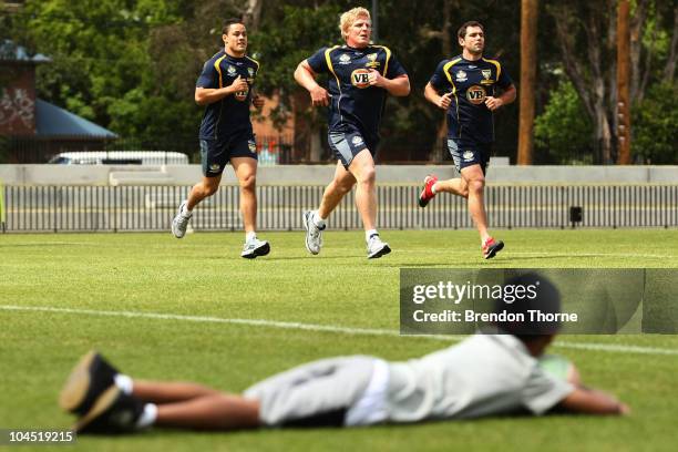 Young boy watches on as Jarryd Hayne, Ben Hannant and Cameron Smith during an Australian Kangaroos training session at Redfern Oval on September 29,...