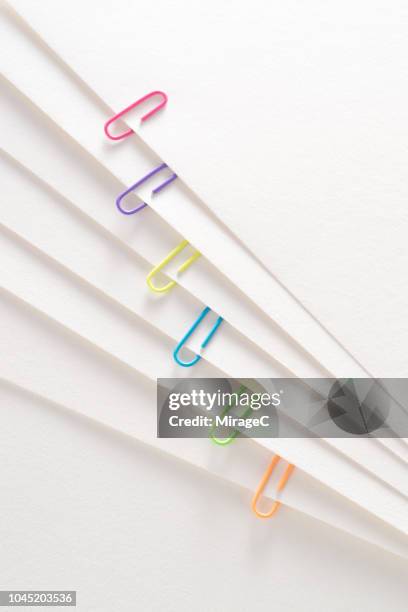 paperclips on layered paper page - paper clip stockfoto's en -beelden