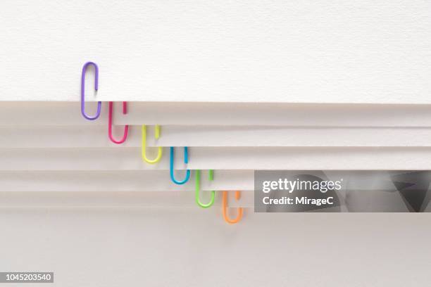 paperclips on layered paper page - paper clip stock pictures, royalty-free photos & images