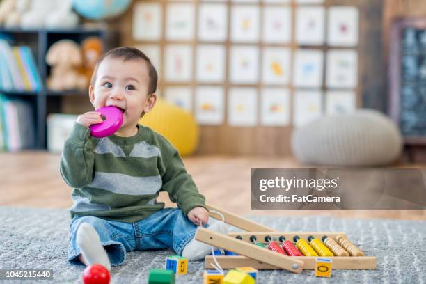 bebé de juguete de masticar - asian baby fotografías e imágenes de stock