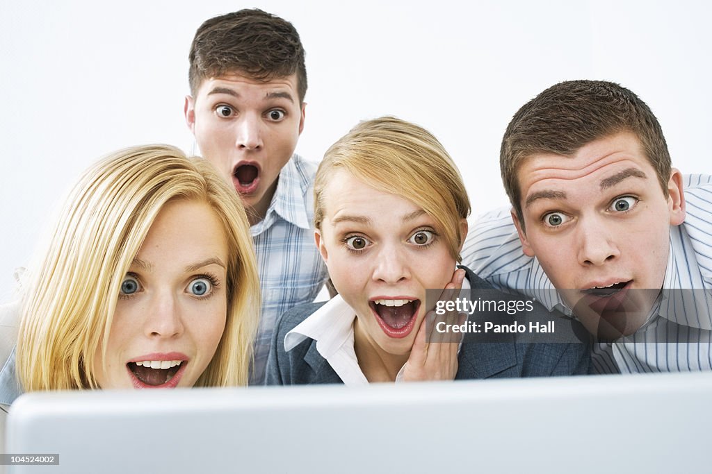 Group of young people looking on laptop, laughing