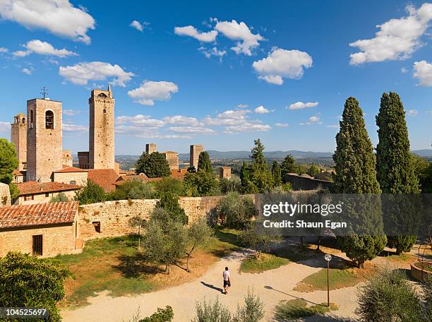 man walking through park in old town - san gimignano stock pictures, royalty-free photos & images