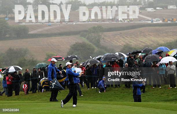 Bookmaker Paddy Power display a large sign on the hillside above the course as Rory McIlroy and Luke Donald of Europe hit shots during a practice...