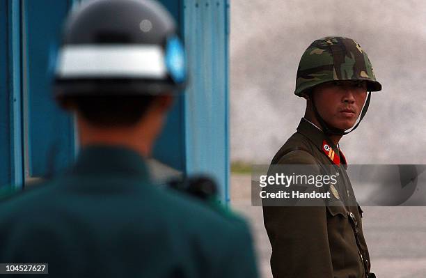 In this handout photo from Chosun Daily News, a North Korean Soldier looks at South Korean soldier at the border village of Panmunjom between North...