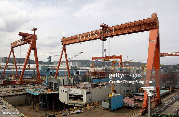 Ship under construction sits at the dock as Hyundai Heavy Industries celebrates 100 million bhp production milestone of 2-stroke diesel engines at...