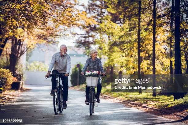 houden van het lichaam sterk met regelmatige fietstochten - healthy older couple stockfoto's en -beelden