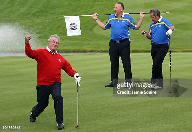 Gareth Edwards celebrates holing a putt as Sir Ian Botham and Sam Torrance look on during a Past Captains round prior to the 2010 Ryder Cup at the...