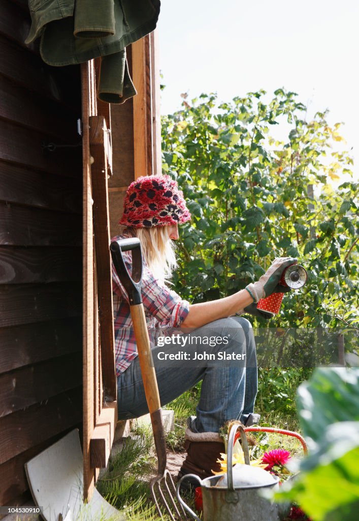 Woman pouring drink in allotment