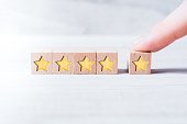 5 Star Ranking Formed By Wooden Blocks And Arranged By A Male Finger On A White Table