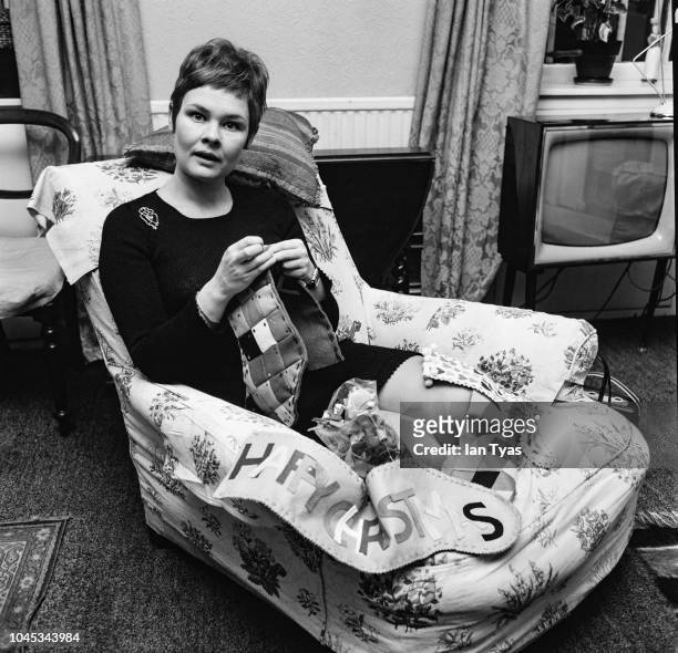 English actress Judi Dench sewing Christmas stockings as gifts for her nephews and friends, December 1967.