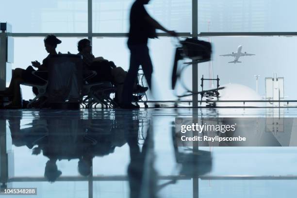 siluetas de pasajeros espera o retraso en el aeropuerto terminal de barcelona, españa - emigración e inmigración fotografías e imágenes de stock