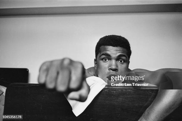 American Heavyweight boxer, Cassius Clay , making a fist as he lies on his hotel bed, London, 27th May 1963. Clay is in London for a match against...