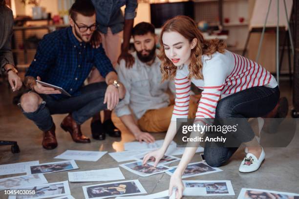 gruppo di persone sedute sul pavimento e guardando le foto - redattore iconografico foto e immagini stock