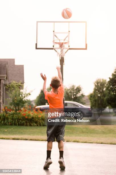 boy shooting free throw - shooting baskets in driveway stock pictures, royalty-free photos & images