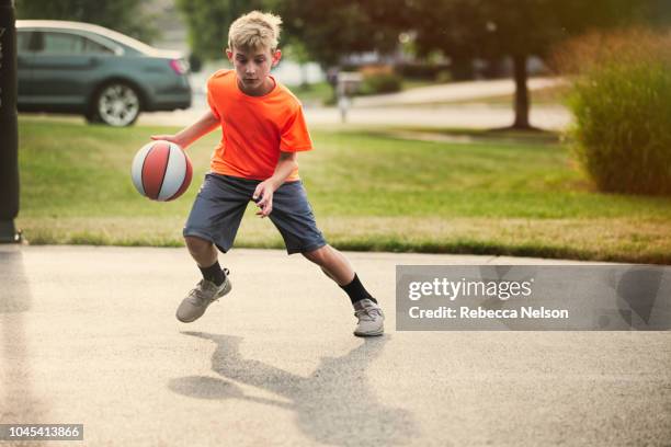 boy dribbling basketball - dribbling sports imagens e fotografias de stock