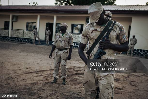 This photograph taken on September 28 shows soldiers as they conduct the daily flag-lowering ceremony at the Force Multinationale Mixte Sector No. 1...