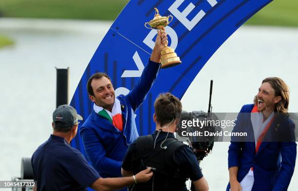 Francesco Molinari of Itlay and the European Team raises the Ryder Cup watched by Tommy Fleetwood after their 17.5-10.5 win over the United States...