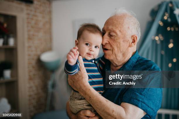 grandpa embracing his little grandson - active baby boomer stock pictures, royalty-free photos & images