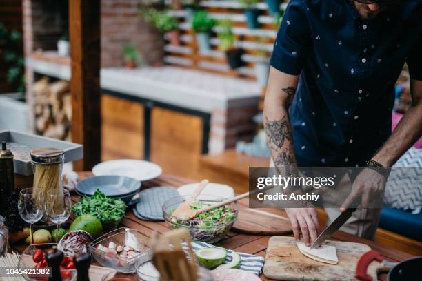 man chopping tortilla to decorate salad - outdoor kitchen stock pictures, royalty-free photos & images